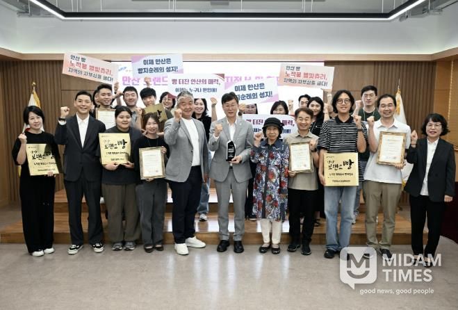 이민근 안산시장이 시청 제1회의실에서 안산 브랜드 빵 ‘노적봉 별빛츄리’ 판매 지정업소 현판 전달식을 진행하고 함께 기념촬영을 하고 있다.