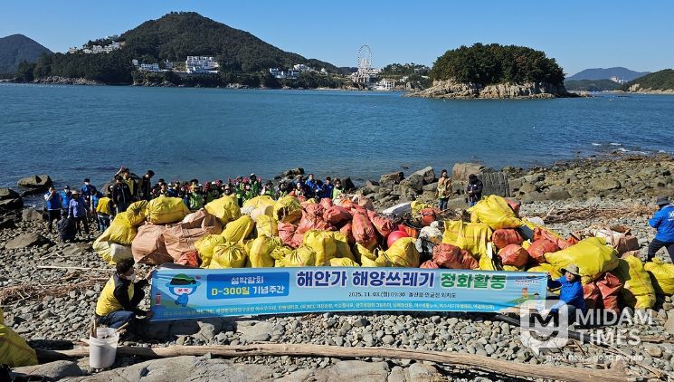 지난 3일 2026여수세계섬박람회 D-300 기념 해양 정화활동에 참여한 시민들이 돌산읍 외치도 해안에서 수거한 해양쓰레기와 함께 기념촬영을 하고 있다.
