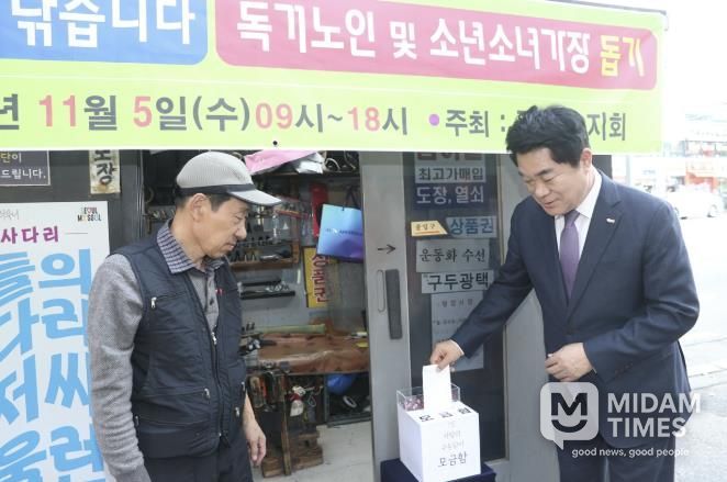 관악구 사랑의 구두닦이 행사에서 모금함에 기부하는 박준희 관악구청장