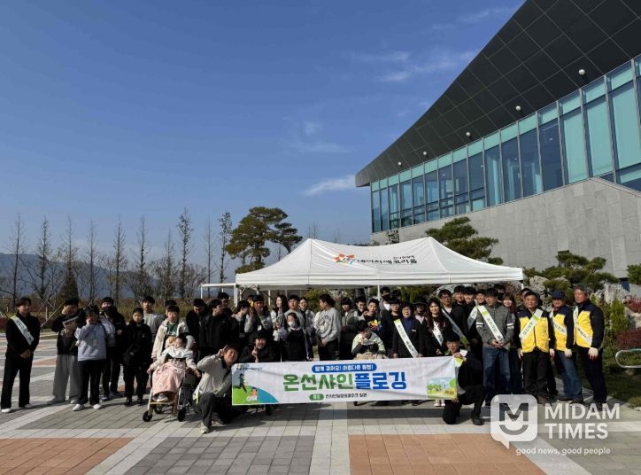 밀양시시설관리공단과 김해 은혜학교 학생들이 선샤인 밀양 테마파크 일대에서 환경정화 활동 후 단체 기념 촬영을 하고 있다