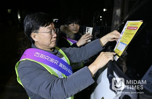 이민근 안산시장이 20일 새벽시간, 단원구 와동 일대에 불법 밤샘주차된 대형차랑에 계도문을 부착하고 있다.