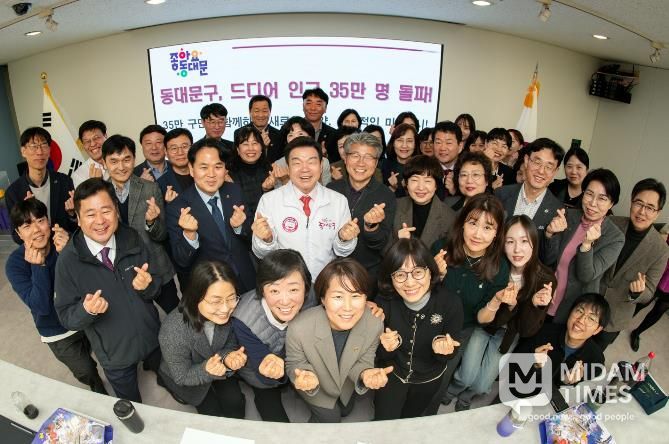 이필형 동대문구청장(가운데)이 직원들과 구민 35만 명 돌파를 자축하고 있다