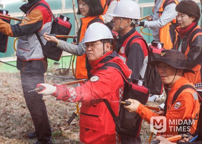 진교훈 서울 강서구청장(가운데)이 25일(수) 개화산 약사사에서 열린 ‘유관기관 합동 산불진압훈련’에서 등짐펌프를 매고 잔불진화작업을 하고 있다.